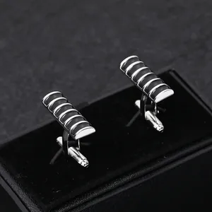 Macro view of French style men's cufflinks with black stripes in a velvet box