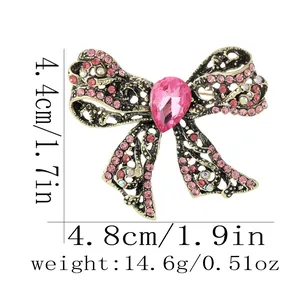 Macro shot of vintage style pink crystal bow brooch with product size measurements