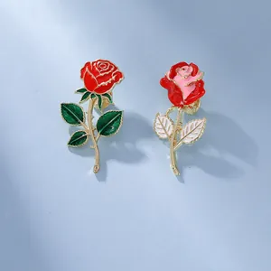 Detaillierte Nahaufnahme von Rosen-Emaille-Anstecknadeln in Rot und Rosa mit Vergoldung