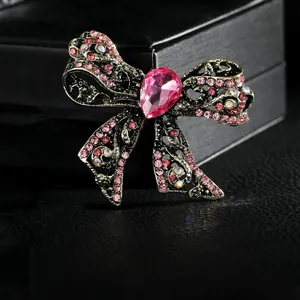 Detailed macro view of vintage bow brooch with pink rhinestones on black leather base