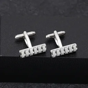 Detail view of silver cufflinks with white rectangular inlay patterns and T-back closure