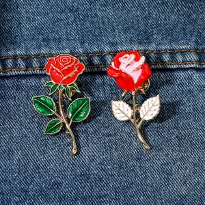 Detailansicht der Emaille-Rosen-Pins in Rot und Rosa auf blauem Denim-Hintergrund