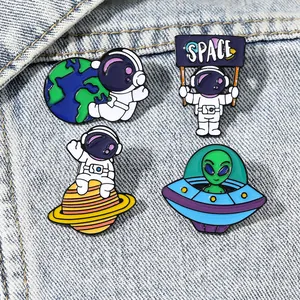 Space exploration enamel pin set with astronaut and alien designs on denim background