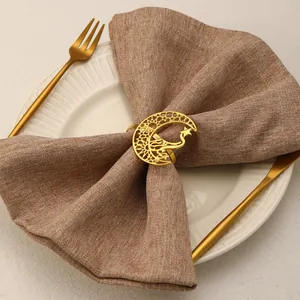 Close-up of golden hollow crescent moon and star napkin ring on a brown cloth napkin