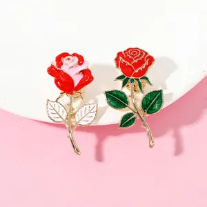 Detaillierte Makroansicht von zwei eleganten Rosen-Emaille-Pins mit vergoldeten Stielen