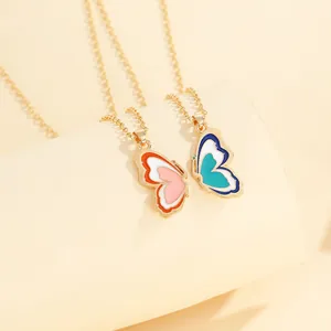 Detail of split butterfly pendant necklaces with vibrant colorful enamel on gold chains