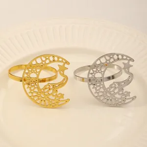 Close-up of hollow moon and star napkin rings in gold and silver on a white plate
