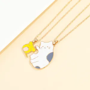 Close-up of cat and hamster split heart pendants with gold chains for couples