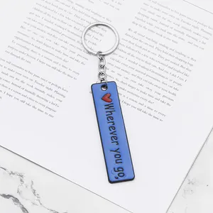 Close-up of blue rectangular keychain with Wherever You Go text and red heart icon
