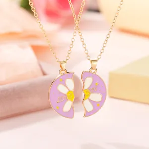 Makroaufnahme von zwei lila Blumenanhängern mit Love You Text und Gänseblümchen-Motiv