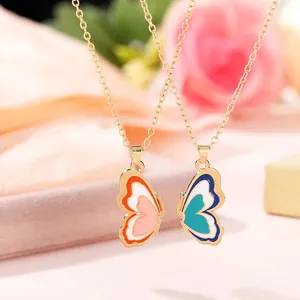 Detail of two-piece butterfly best friend necklaces with gold chain and enamel butterfly pendants