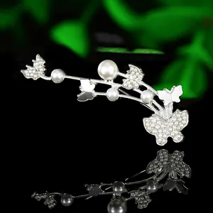 Detailed close-up of luxury wheat ear and butterfly brooch with pearls and rhinestones