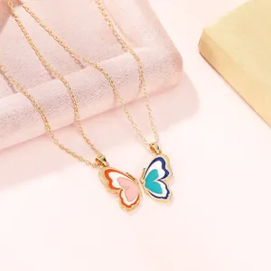 Detailed close-up of colorful butterfly puzzle pendants on two gold link chains