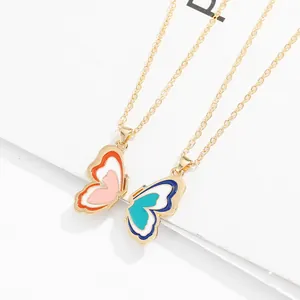 Detail of magnetic butterfly pendants with colorful enamel inlay on gold-plated chain