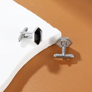 Close-up of hexagonal silver cufflinks with black enamel inlay and T-bar fastenings
