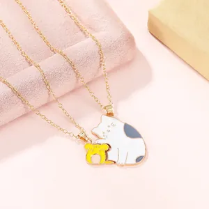 Close-up of golden necklace featuring a cute cartoon oil-dripped cat and mouse pendant