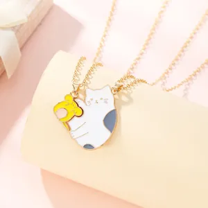 Detail of interlocking cat and mouse enamel puzzle necklace pendants in gold finish