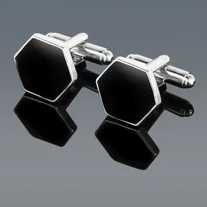 Close-up of geometric cufflinks with silver frame and black hexagonal inlay detail