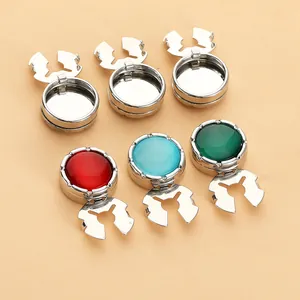 Detalle de bases de gemelos redondos de metal con inserciones de gemas rojas, azules y verdes