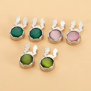 Primer plano de seis botones metálicos decorativos vintage con piedras de colores