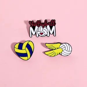 Détail de trois épingles en émail sur le volley-ball incluant Volleyball MOM et cœur ailé