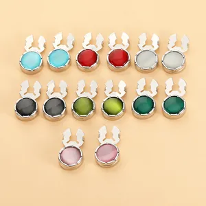 Detalle de piedras de resina redondas de colores en bases de metal plateado para camisas