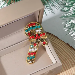 Detailed view of a candy cane brooch with red and green rhinestones in a festive gift box