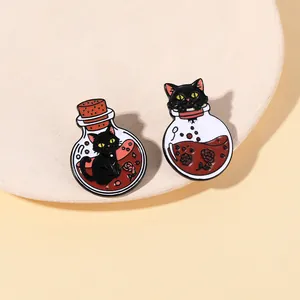 Close-up of two cartoon black cat enamel pins inside potion bottles on a display tray