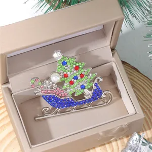 Detail of Christmas sleigh brooch with colorful rhinestones in a gold jewelry box