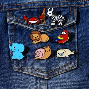 Set of seven cartoon animal enamel pins displayed on a blue denim jacket pocket