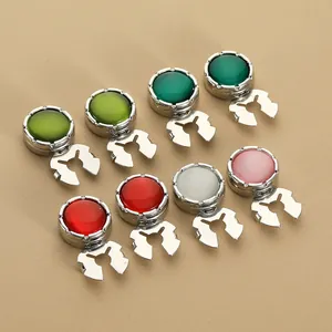 Detalle de ocho gemelos decorativos coloridos con base de metal plateado pulido
