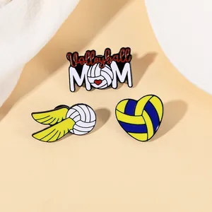 Détail de trois broches en émail sur le volley-ball avec texte Volleyball MOM et cœur ailé