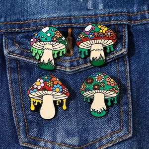Artistic mushroom enamel pins with floral patterns pinned on blue denim jacket pocket