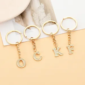 Detailaufnahme goldener Metall-Buchstaben-Schlüsselanhänger O C K F mit Struktur