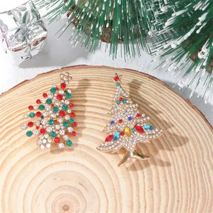 Elegant Christmas tree crystal brooches on wood with festive ornaments and pine needles