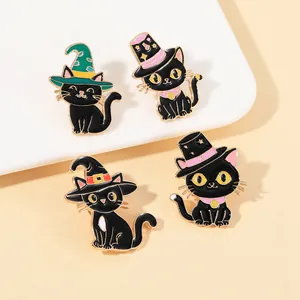 Close-up of four black cat enamel pins featuring wizard hats on a white ceramic display plate