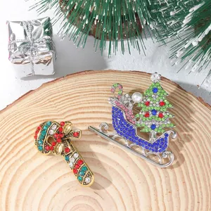 Detailed close-up of candy cane and sleigh Christmas brooches with colorful rhinestones