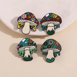 Close-up of four mushroom enamel pins with floral patterns and dripping liquid effect