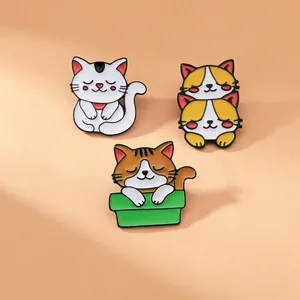 Vista dettagliata di tre spille in smalto a forma di gatto con colori vivaci e contorni neri