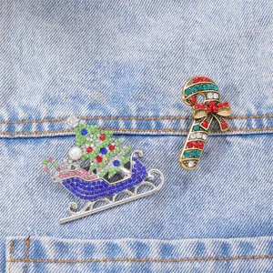 Sparkling Christmas tree and candy cane brooches with colorful rhinestones on denim