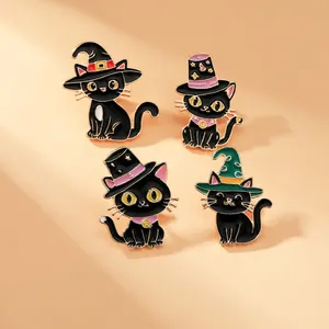 Set of four black cat enamel pins with colorful wizard hats on a soft peach background