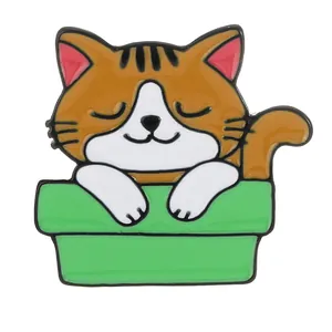 Spilla creativa in smalto con gatto soriano arancione che dorme in una ciotola verde