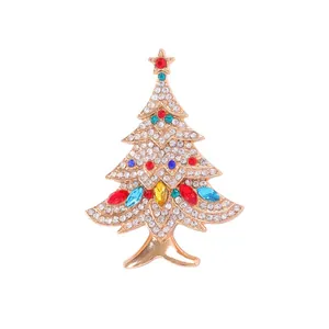 Golden Christmas tree brooch with colorful rhinestones and a red star on white background