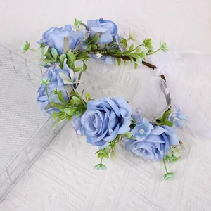 Bohemian floral crown with blue fabric roses and green leaves on vine headband