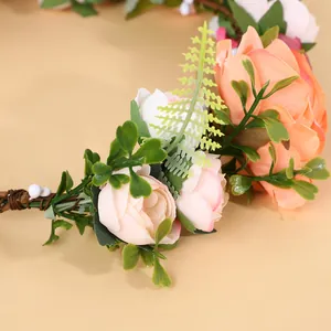 Nahaufnahme von rosa und orangen Kunstrosen am Braut-Blumenkranz für Hochzeitsfotografie