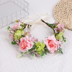 Detail eines handgefertigten Blumenkranzes mit rosa Rosen und Seidenbändern