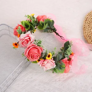 Detailansicht eines Blumenkranz mit rosa Rosen, grünen Blättern und Organzaband