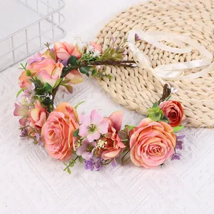 Detail von handgemachtem Rosenkranz mit rosa-orangen Blüten und Satinband-Bindung