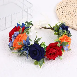Detail eines Blumenkranzes mit Seidenrosen, Beeren und Bändern auf einem Tisch