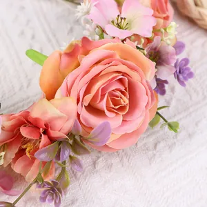 Nahaufnahme eines realistischen Blumenkranzes mit Samtrosen, rosa Blüten und grünen Blättern